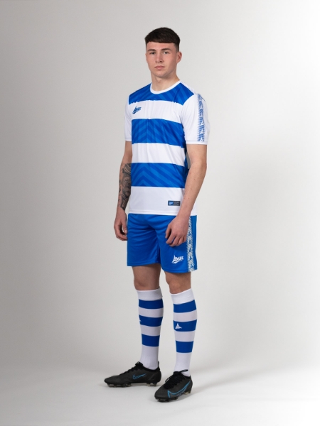 An adult is wearing a blue and white hoop football shirt with blue shorts and blue and white hooped socks