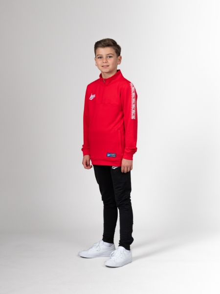 This child is wearing a red jumper with black tracksuit bottoms