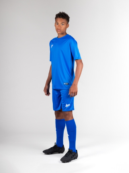 A child is wearing a full blue football kit