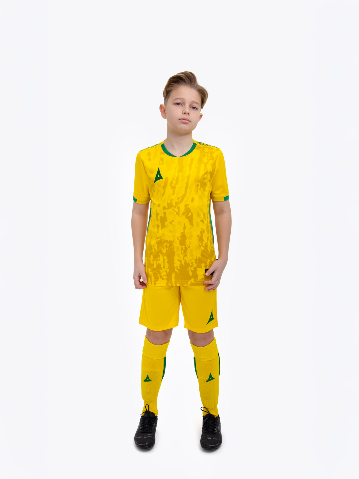 a kids football kit in yellow and matching red shorts and socks with green accent details