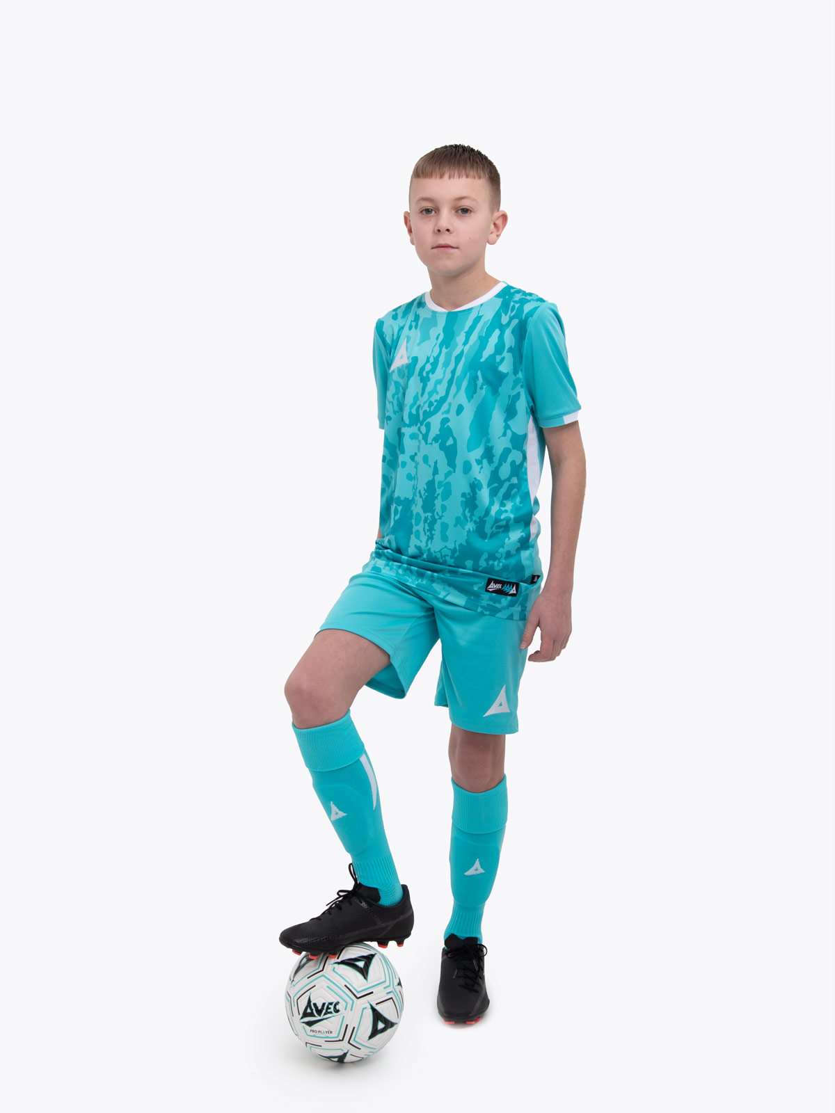 a kid standing up wearing a hyper blue football shirt, matching hyper blue shorts and hyper blue football socks.