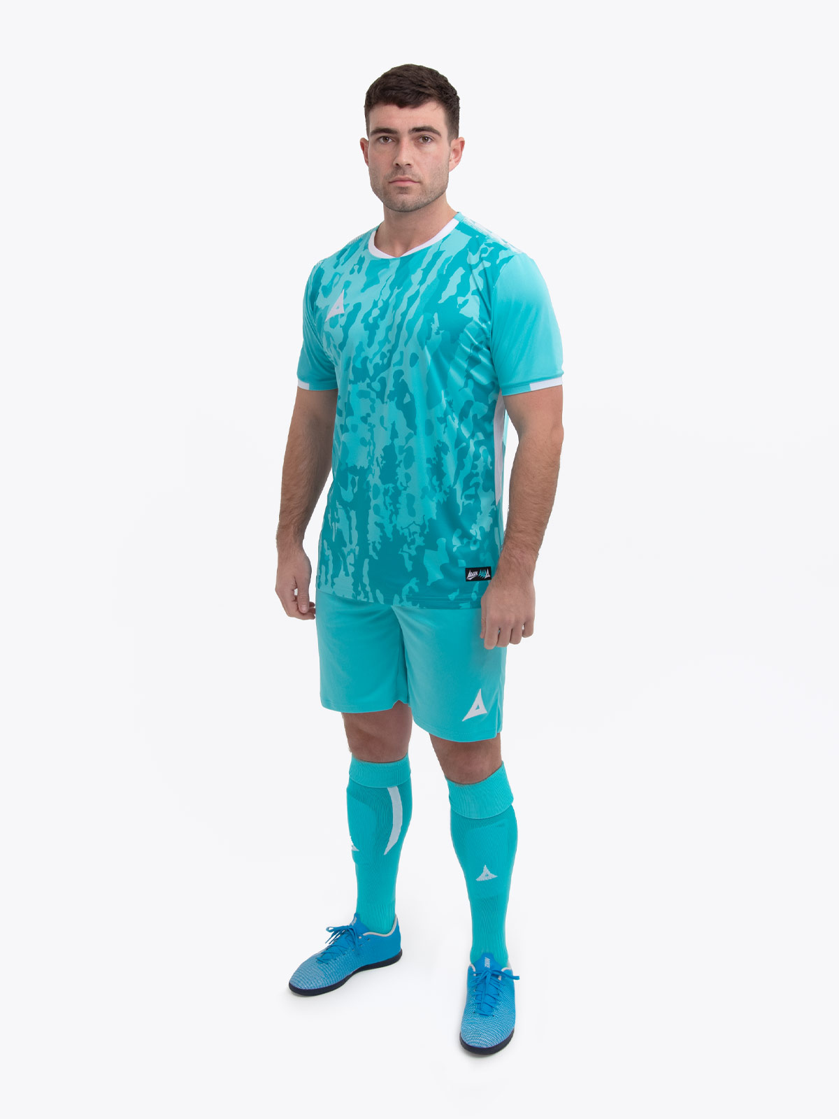 a man standing up wearing a hyper blue / white football shirt, matching shorts and football socks.